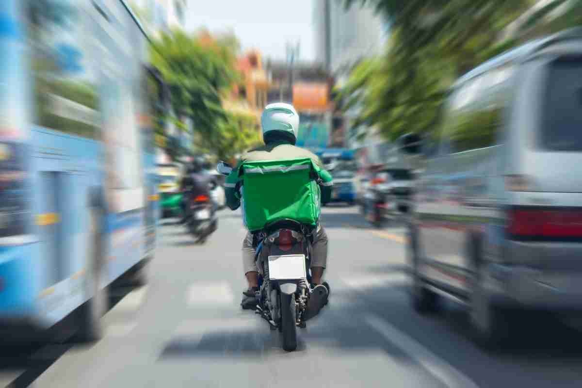 food delivery driver on scooter in traffic